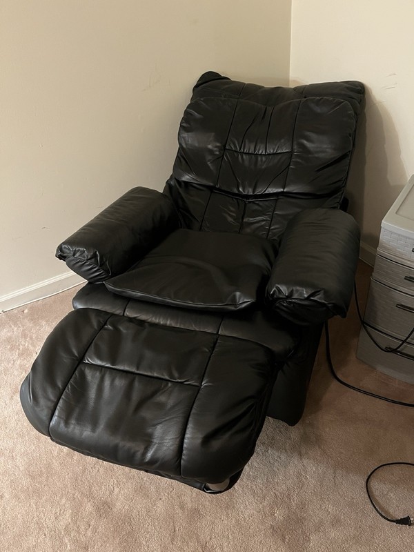 Black leather reclining massage chair with remote control attached for Options